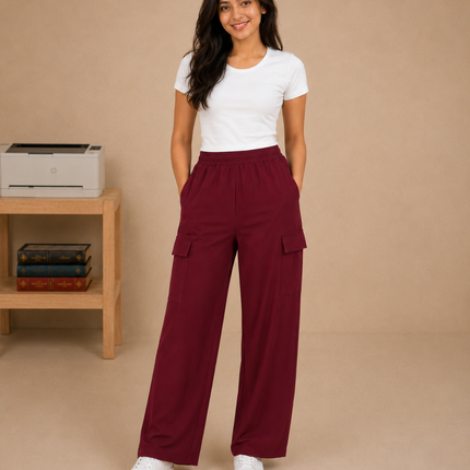 Woman wearing maroon cargo pants and a white t-shirt on a beige background